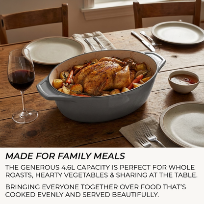 Casserole Dish with roasted chicken and vegetables on a wooden table with plates and wine glasses.