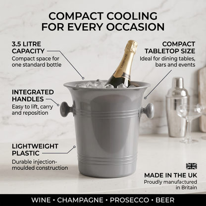 A gray compact ice bucket with a champagne bottle inside, shown on a light marble surface with callout text describing its features: 3.5 litre capacity, compact tabletop size, integrated handles, lightweight plastic construction, and made in Britain.
