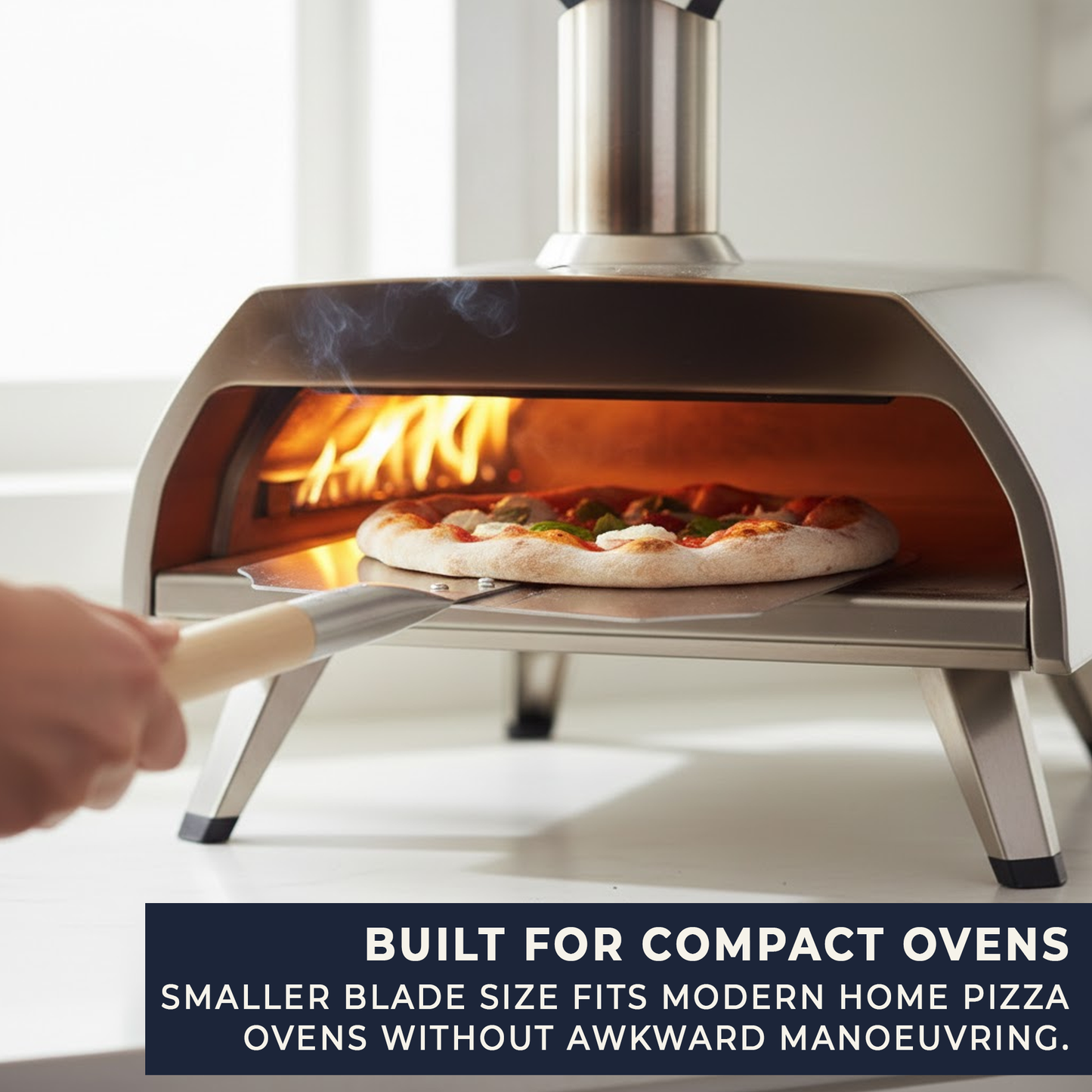 Aluminium pizza peel launching pizza into compact home pizza oven with safe long handle